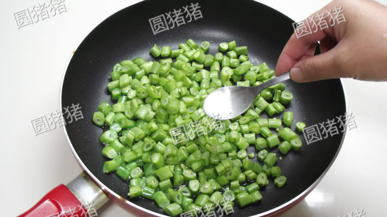 榄菜肉末炒豆角,炒锅热少许油，先放入豆角，1/4小匙盐，用小火煸炒。