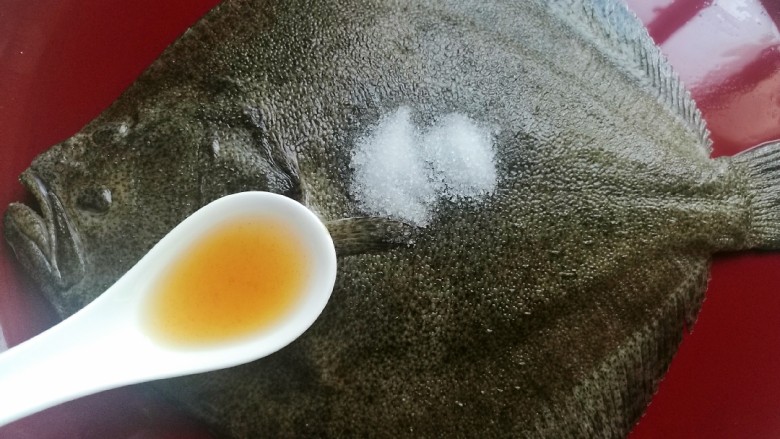 清蒸多宝鱼,在鱼身上洒入盐,淋入<a style='color:red;display:inline-block;' href='/shicai/ 718'>料酒</a>。