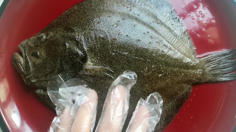 清蒸多宝鱼,戴上一次性手套,在鱼身上涂抹均匀,腌制二十分钟备用。