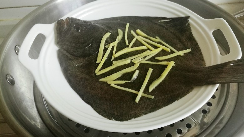清蒸多宝鱼,锅中放水,用大火烧开,把多宝鱼放入蒸架上。
