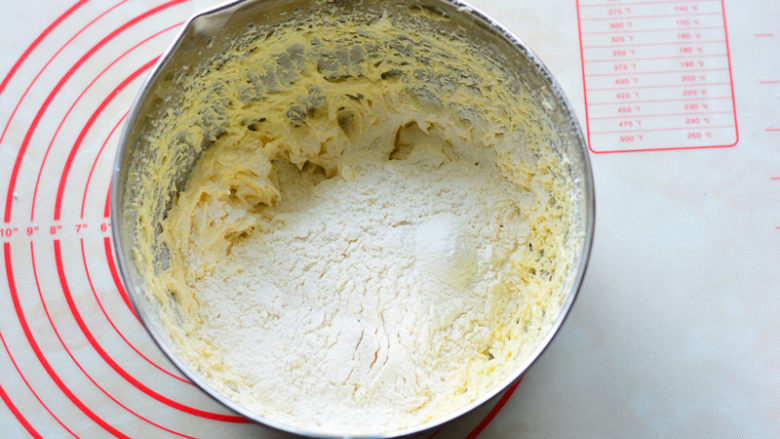 酸酸甜甜如云朵般口感的百香果磅蛋糕,筛入低筋面粉和泡打粉，（过筛的主要作用是可以去除粉类储存过程中产生的结块，让面粉更蓬松），用手动打蛋器搅拌至面粉无颗粒状