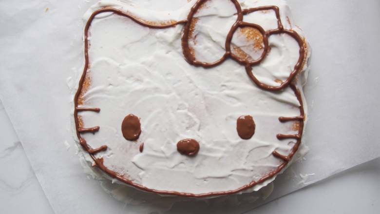 Hello Kitty 奶油蛋糕,<a style='color:red;display:inline-block;' href='/shicai/ 874'>巧克力</a>融化后装入裱花袋,剪开小口,沿着蛋糕边缘画出形状。