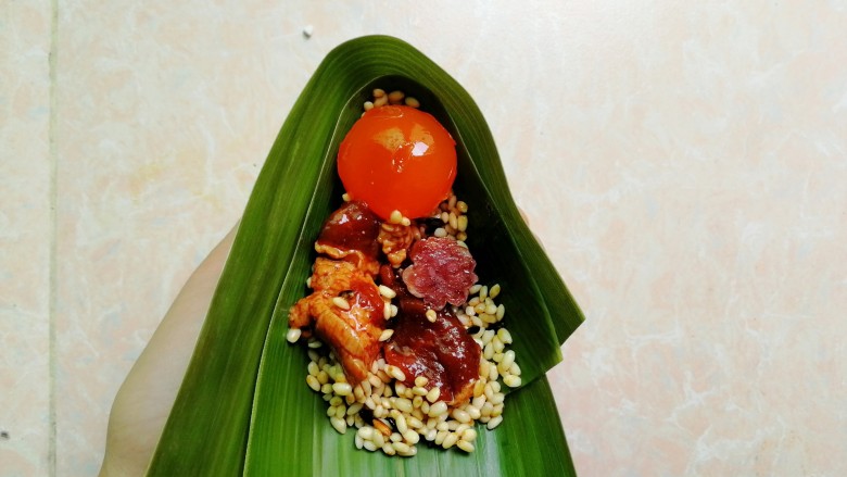 五花肉咸蛋黄腊肠粽,均匀摆放好蛋黄,五花肉和腊肠
