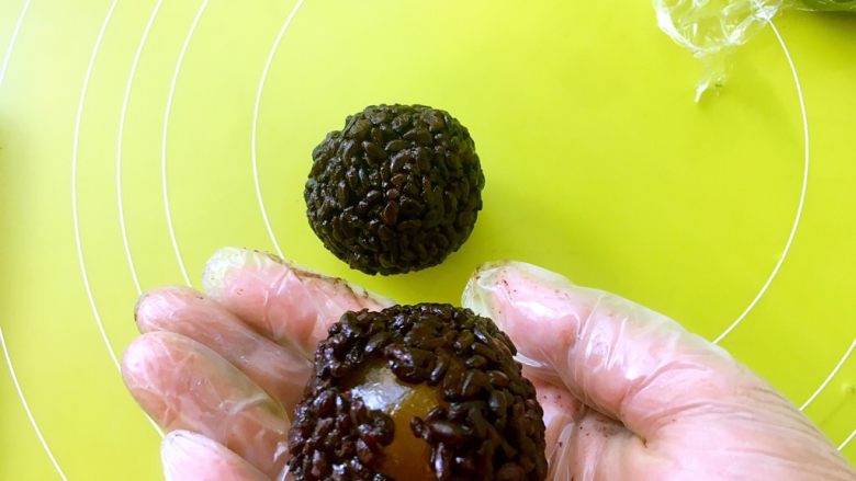 情有独“粽”,手上戴一次性手套,将紫米饭压扁,包裹上咸蛋黄