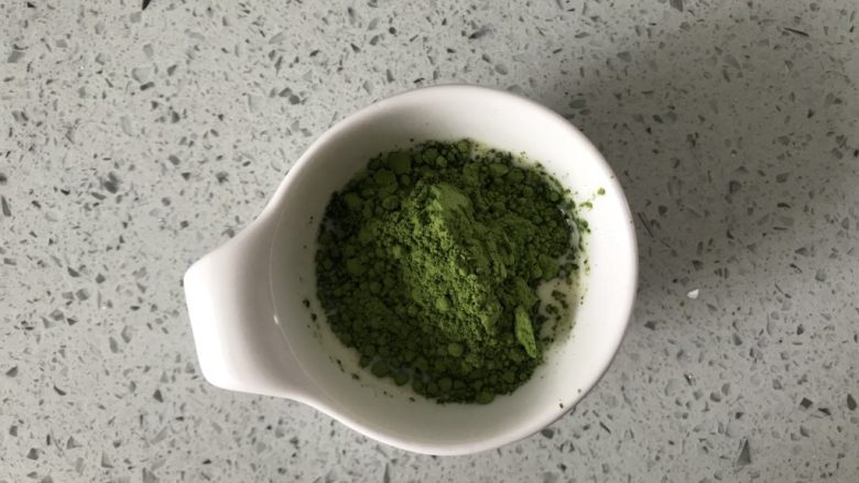 抹茶蜜豆恐龙蛋,另取一个小碗,加入适量牛奶鸡蛋混合液体,再倒入抹茶粉。