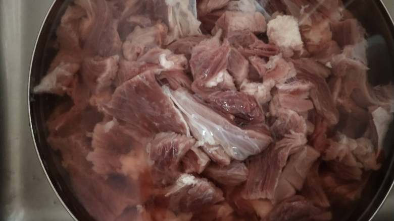 五香牛肉干,把泡出血水的牛肉顺纹理切成均匀的大概手指粗细的长条!然后再清洗一遍去血水