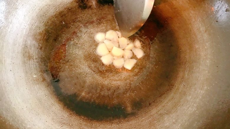 洋葱炒肉片,锅中热油，放入蒜片，炒香。