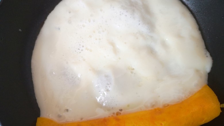 双色厚蛋烧,将卷起来的蛋卷朝自己方向拉过来后再倒入少许蛋白液