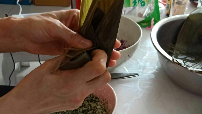 彩色果干甜粽子和咸味肉粽子,不要放太满,压平,缠的时候往上部缠缠。
