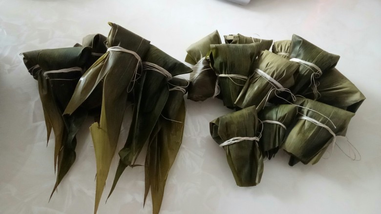 彩色果干甜粽子和咸味肉粽子,全部包好,没剪的是肉粽子,剪去的是甜粽子。