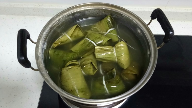 彩色果干甜粽子和咸味肉粽子,放入锅中,加入抹过粽子的水。