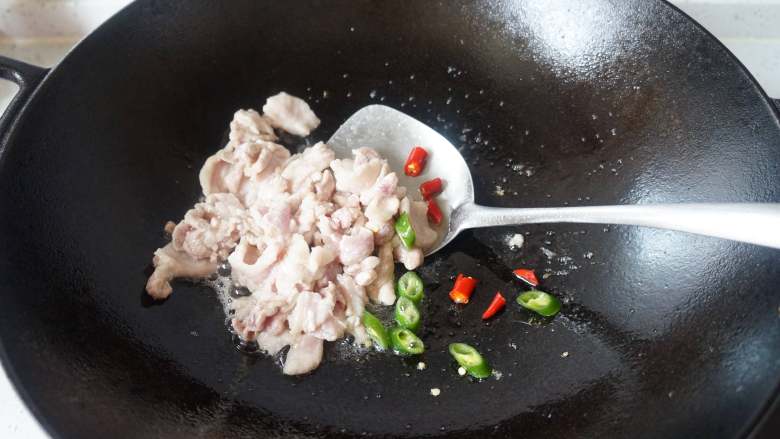 泡菜豆腐汤,热锅凉油倒入五花肉翻炒几下,放入辣椒翻炒至肉变色