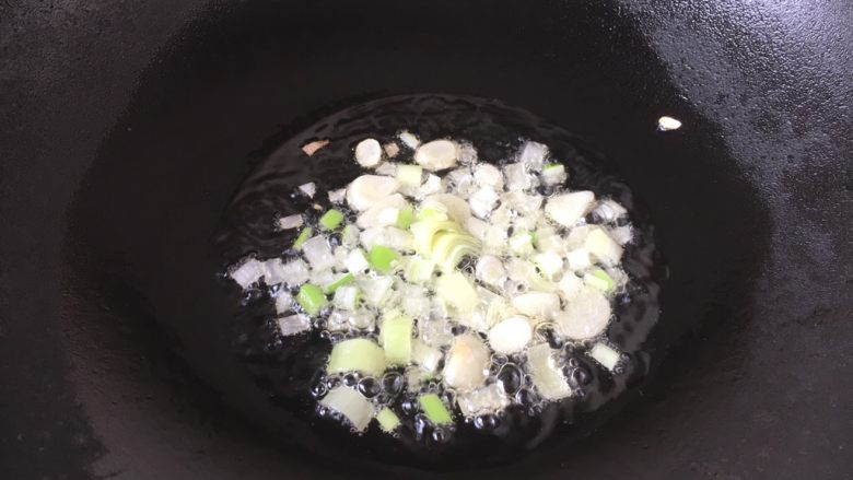 孜然辣椒土豆,热锅凉油,放入蒜片和葱花炒出香味。