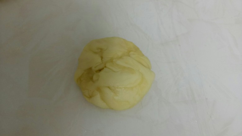 红糖酥饼,取一份,用母指从中间压一下,两头收到中间,再用手压扁。