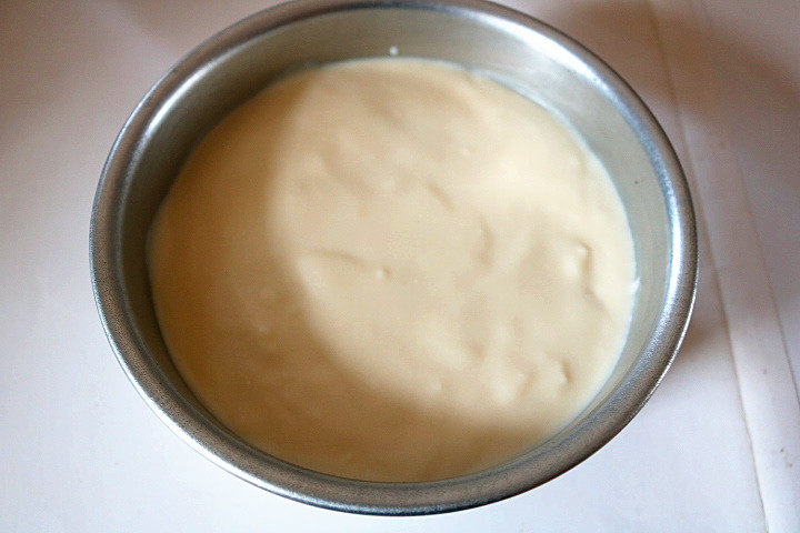 豆腐提拉米苏,再铺上1/3的奶酪糊,轻震模具,铺平奶酪糊。