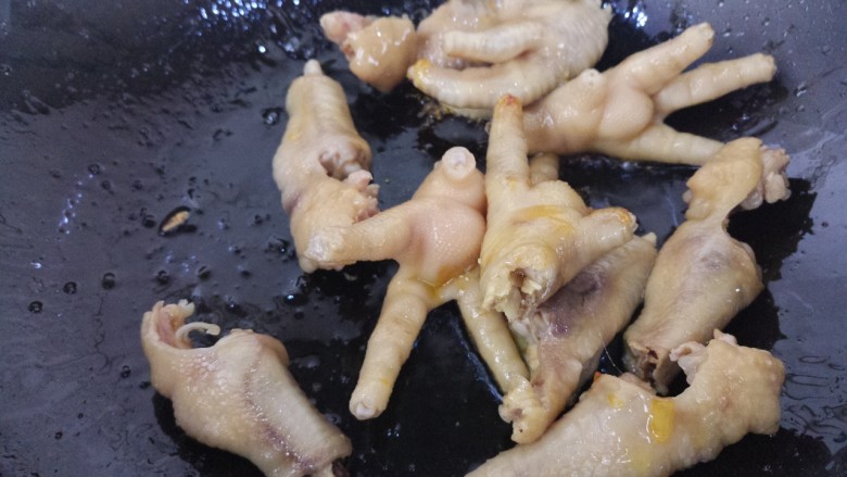 鹌鹑蛋凤爪,然后倒入凤爪,快速翻炒。凤爪的水要滤干,不然会溅油。