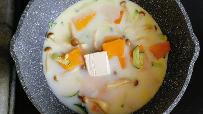 宝宝辅食—南瓜猪肉奶酪烩意面,接着倒入半碗清水和一块宝宝奶酪,中火煮开转小火慢煮