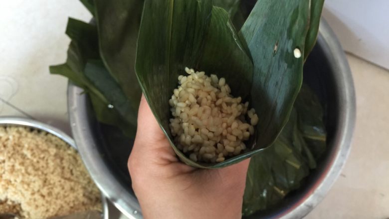 香香肉粽,加入一勺糯米,用筷子捅紧米粒