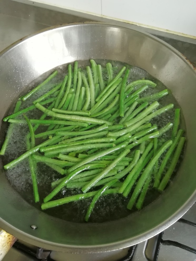 凉拌麻辣长豆角,将豆角用手掰成10公分的段,下开水焯3分钟,水里加几滴油,焯好捞起过凉水