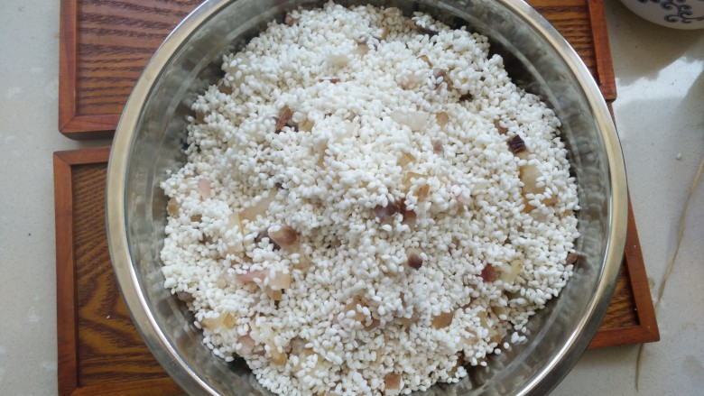 不同类型粽子的包法,糯米和腊肉搅拌均匀,糯米没有用水泡过,是干的,包的时候不用包得特别紧,要不然糯米吸水胀大了容易裂开。