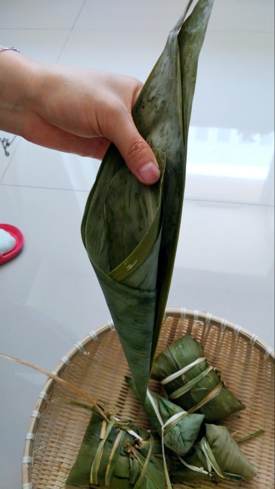 不同类型粽子的包法,两张粽子叶,用大头往里卷两圈,保证地端不漏米。