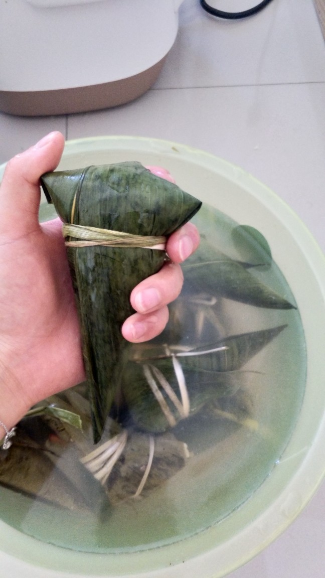 不同类型粽子的包法,用绳子绑住最后叶子对折的地方,包子不漏米。三角粽子也就包好了。