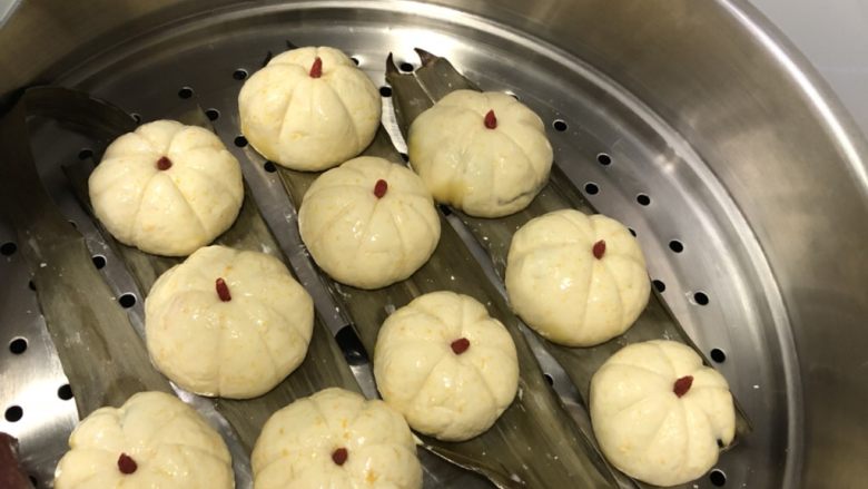 南瓜糯米糍,分成等量12份面团,压平包入豆沙馅,用牙签花米子纹,中间放上红枸杞点缀