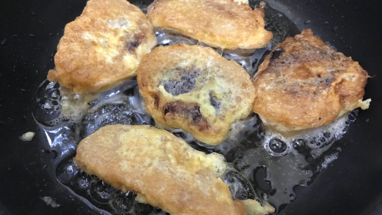 粽子新吃法-抱蛋煎粽子,待锅内油七分热时,将粽子片放入鸡蛋液,两面粘上鸡蛋液后放入锅内,小火将粽子两面煎到金黄,盛出备用