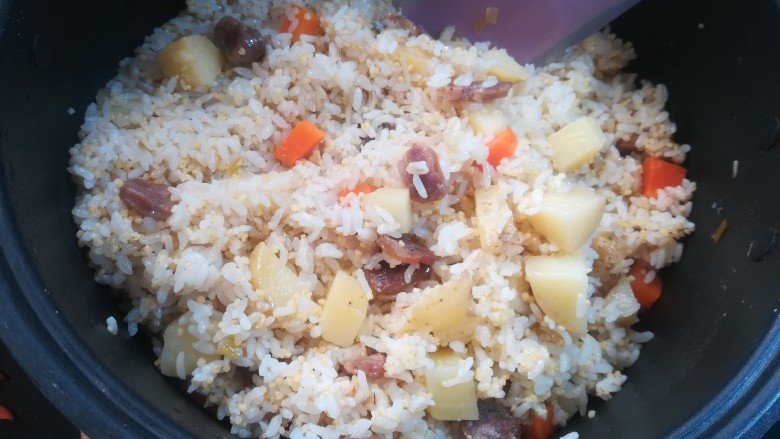 腊肠土豆焖饭, 用铲子慢慢的把米饭和上面的蔬菜腊肠拌匀,不要太大力哦,土豆已经蒸的很酥烂,用力的翻搅会碎掉。