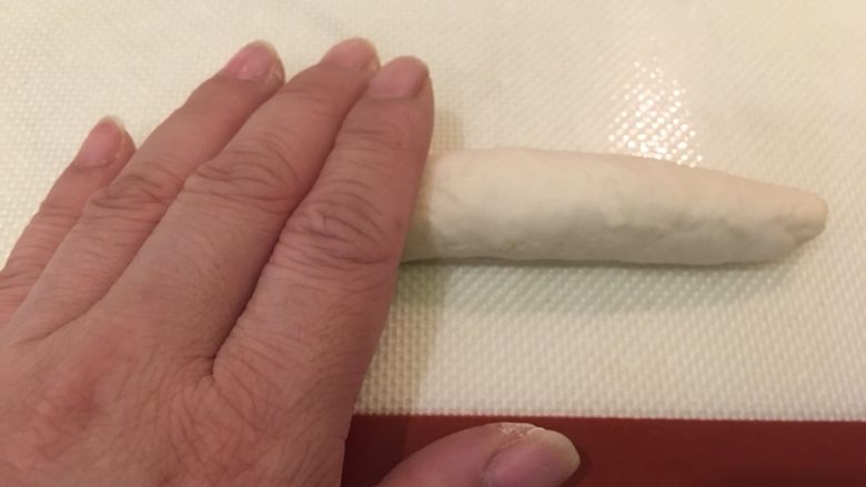 奶酪面包圈,此时面团已成条状,双手一起将条状搓平滑变长