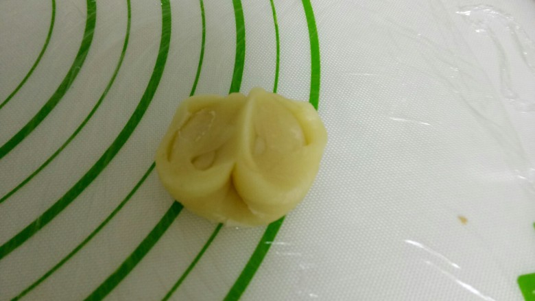 开口酥,取一个卷,用拇指从中间压一下,两头往上收。
