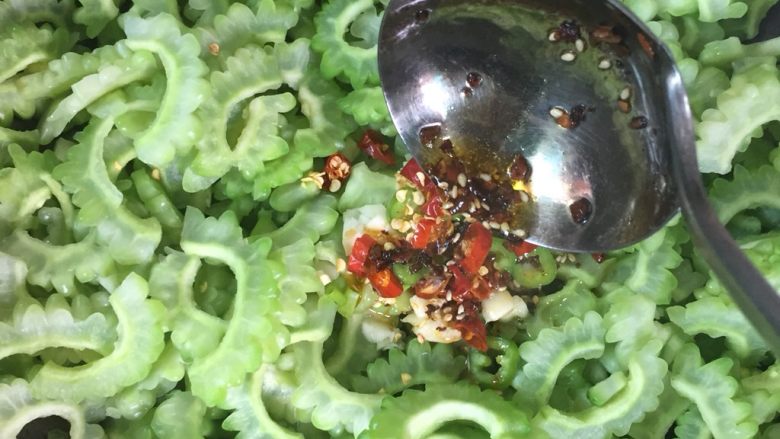 凉拌苦瓜,切好的辅料取一点放入苦瓜之上、烧热的辣椒油浇在辅料上