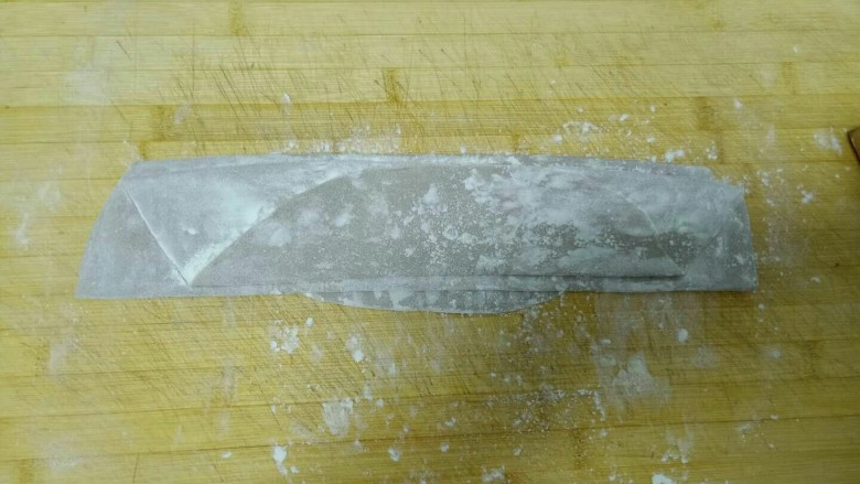 丝瓜炒鸡蛋拌黑米手擀面,均匀撒上干面粉，折叠起来。