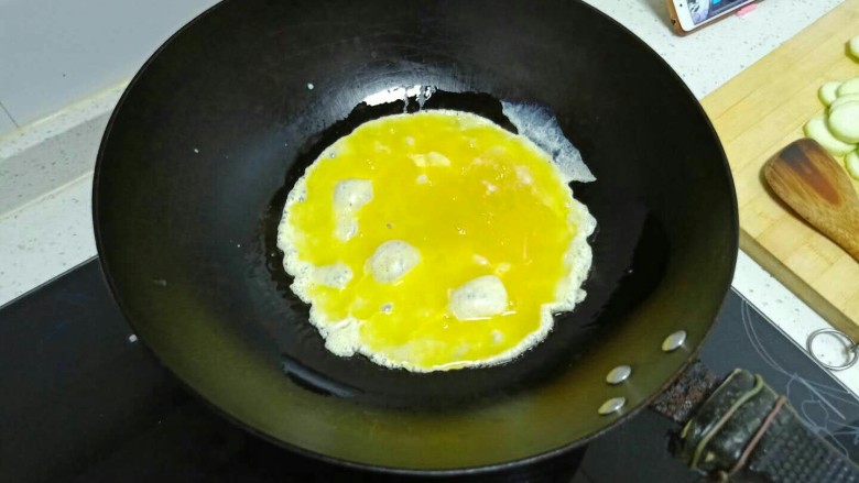 丝瓜炒鸡蛋拌黑米手擀面,锅中放入适量油，油热后倒入鸡蛋。