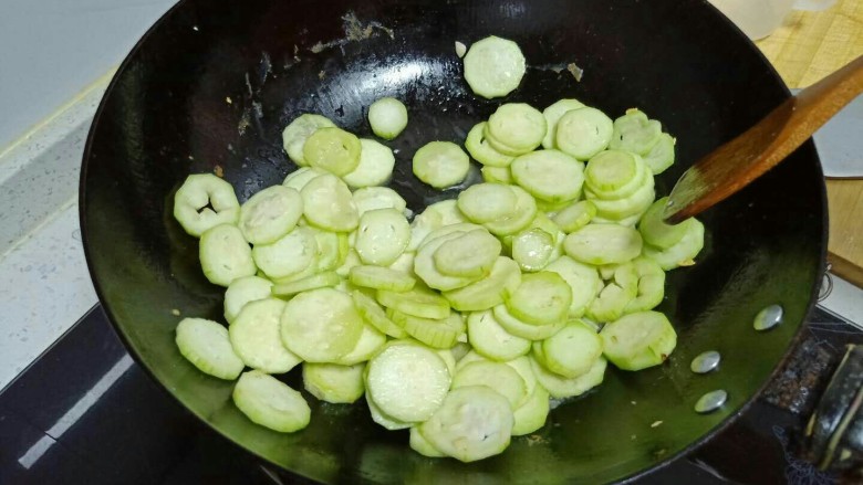 丝瓜炒鸡蛋拌黑米手擀面,倒入丝瓜片。