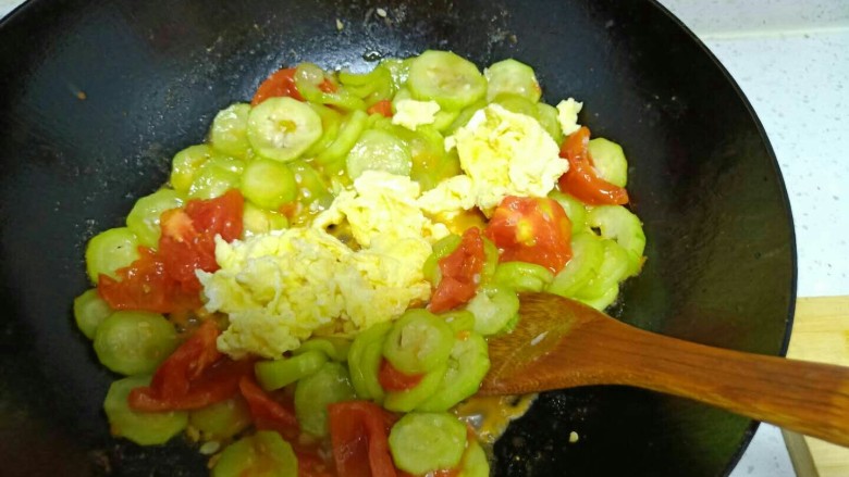 丝瓜炒鸡蛋拌黑米手擀面,待西红柿变软，倒入鸡蛋。