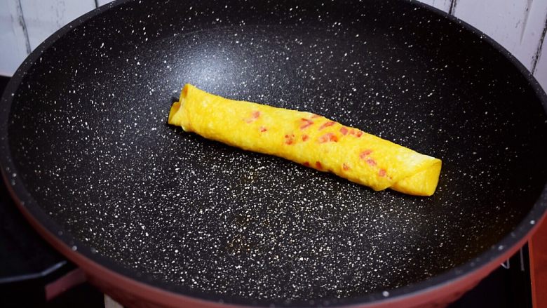 番茄厚蛋烧,小火煎至底部凝固时,从一边卷起