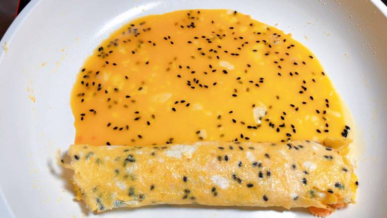【宝宝辅食】三文鱼松厚蛋烧,把卷好的蛋卷移到锅的另一端,把剩下的蛋液加入锅中