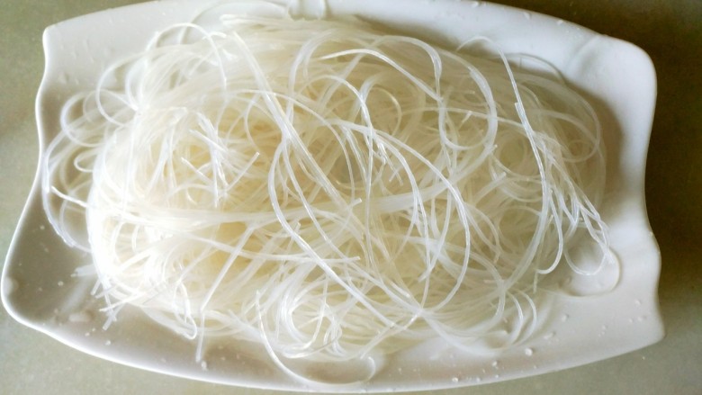 蒜蓉粉丝开边虾,把泡好的粉丝捞出控干水份,粉丝放在盘子里
