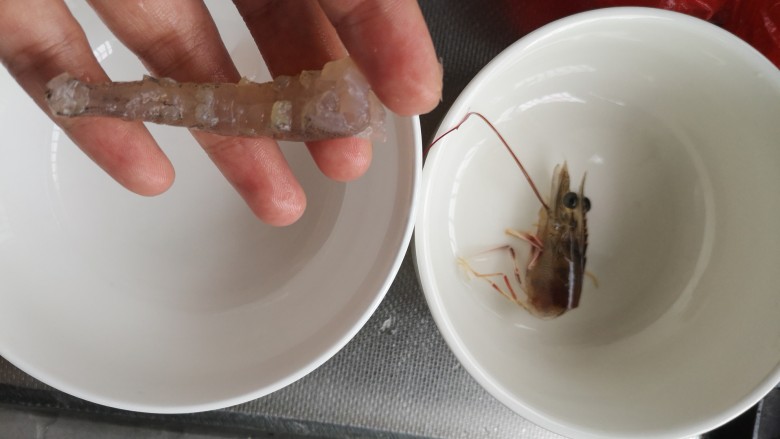 茄汁虾仁油豆腐,备两个干净碗
一个里面放虾头(用来烧汤,味道鲜美)
一个里面放剥去虾壳、抽去虾线的虾尾