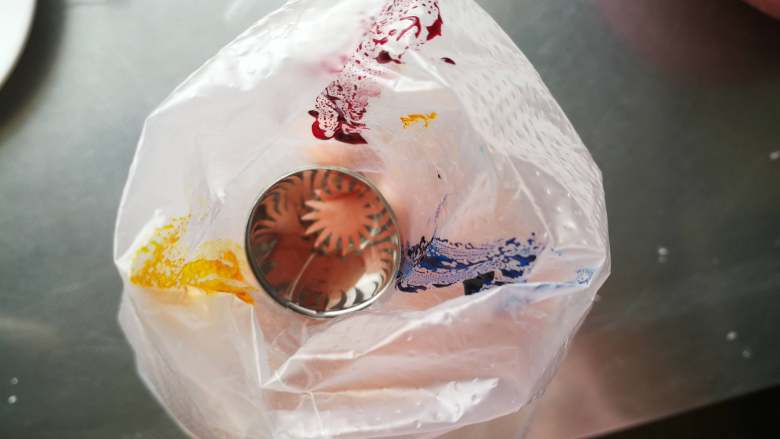 五彩蛋白糖,我用了蓝色、黄色和粉色。用小刷子刷入装好裱花嘴的裱花袋。(裱花嘴用8、12、18齿或圆孔等等都可以,我觉得齿越多的越好看呢,建议用大号裱花嘴)