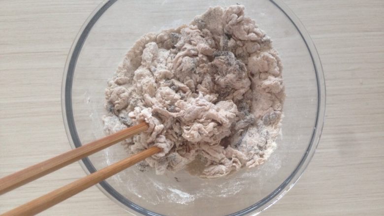 黑芝麻褐麦馒头,缓慢倒入酵母水,一边倒,一边用筷子拌。
