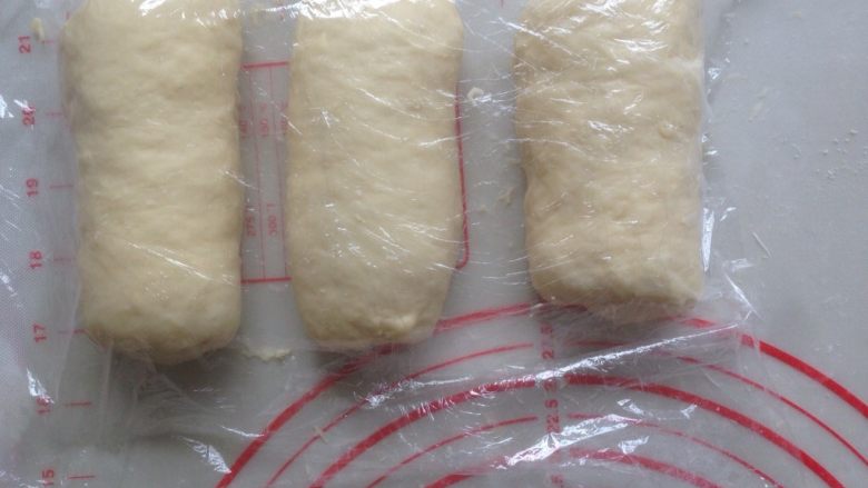酸奶吐司,翻面,卷起,盖保鲜膜,再松驰15-20分钟