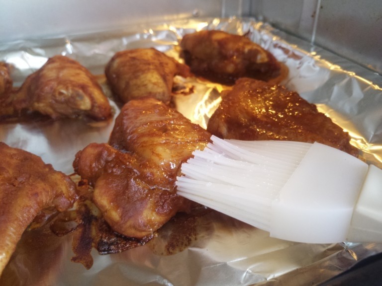 自制烤鸡翅,十五分钟之后打开烤箱,在鸡翅的表面上刷上蜂蜜。