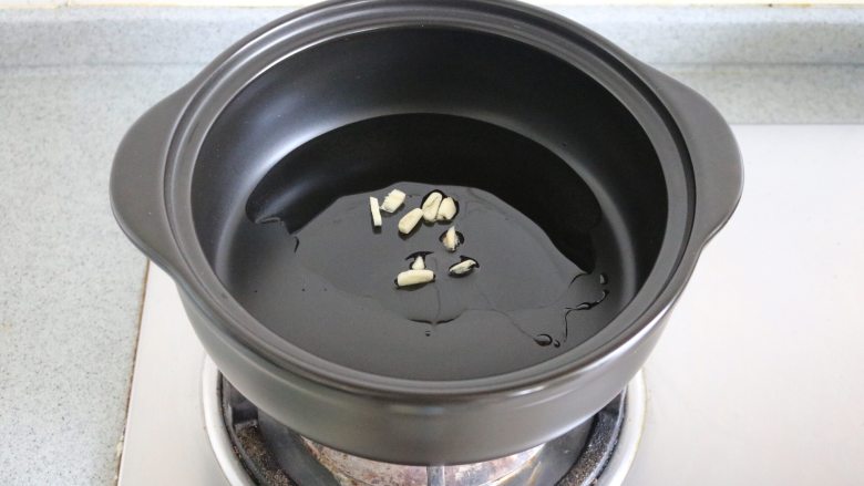 砂锅爆炒荷兰豆,油7分热时放入蒜末,中火翻炒;