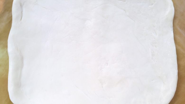 麻酱核桃手撕包,冰箱取出冷冻的面片，揉面垫上撒点干粉，将面片移到揉面垫上