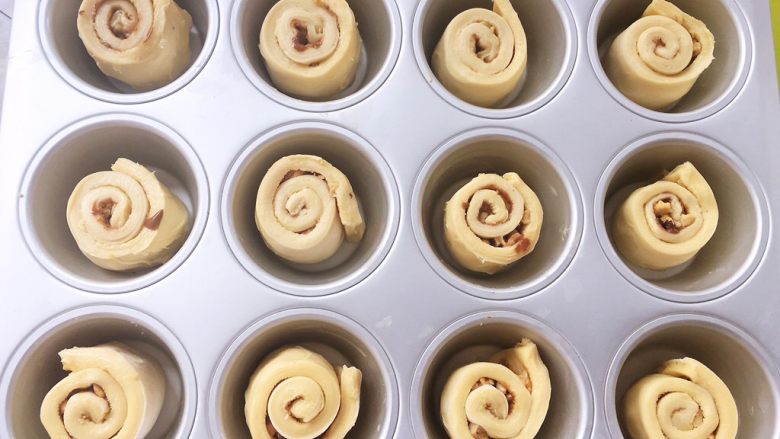 麻酱核桃手撕包,放入宜家•瓦达恩12连模内，室温二次发酵，裁掉的边角也别丢掉，可以分成4、5份，压在模具底部一起烤，也可以单独扭成麻花，放在旁边一起发酵烘烤