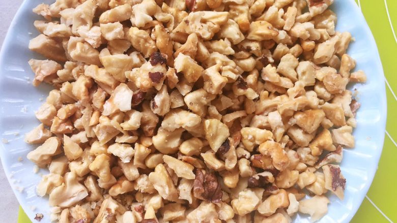 麻酱核桃手撕包,出炉取出核桃仁，烤过的核桃仁轻轻搓一下就可以去掉表皮，之后将核桃仁压碎备用