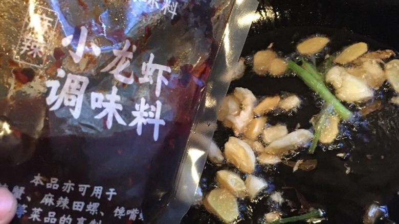 麻辣小龙虾,锅里放少于油,烧热后将姜蒜头葱段放入翻炒,小火加入半包海底捞小龙虾调味料稍微翻炒一下