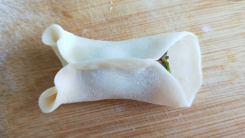 小鱼鲜虾蒸饺,在合起来捏紧,在把折的边翻出来中间捏紧,就是两个眼睛。